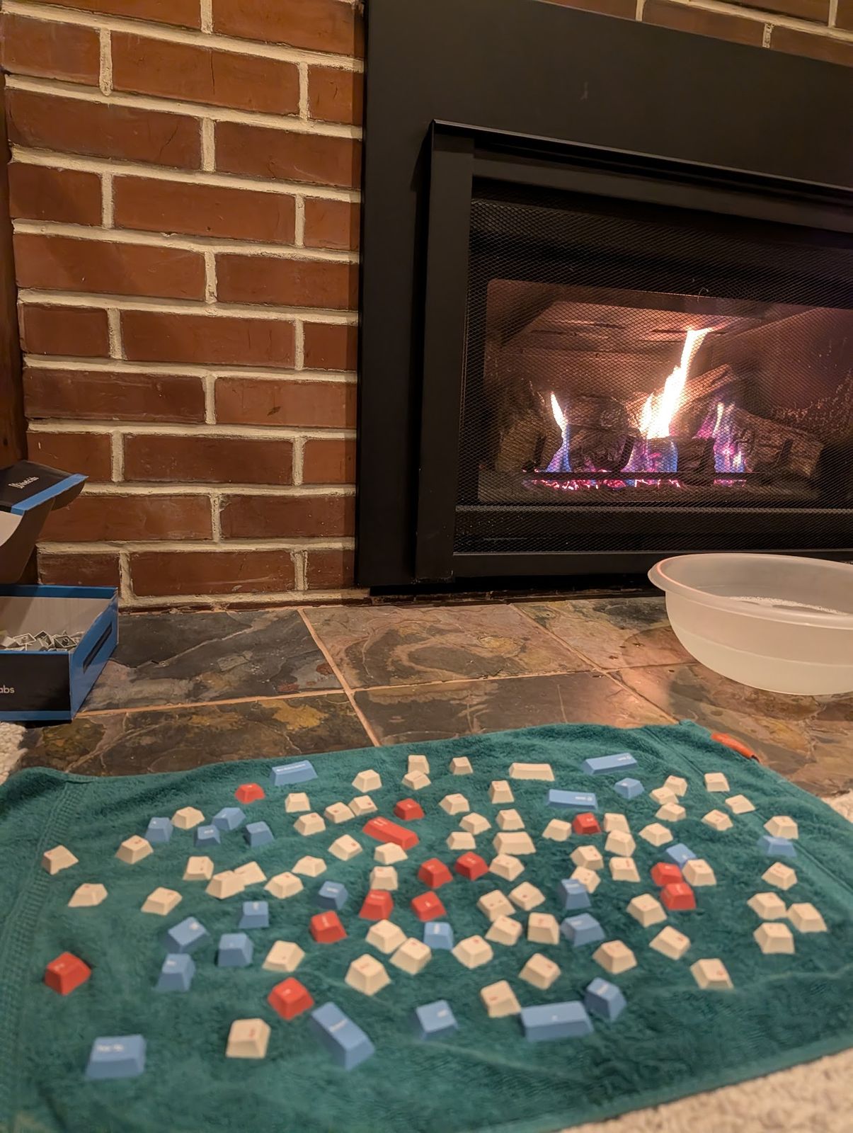 Clean keycaps laid out to dry on a towel by the fireplace